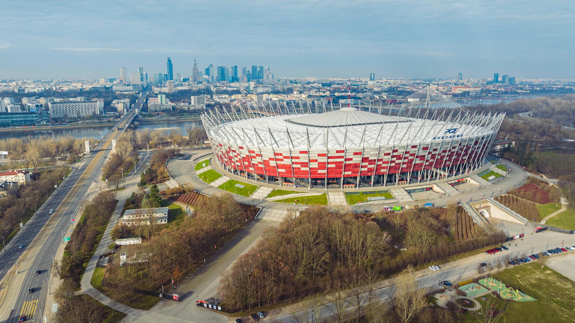 Ilustracja symbolizująca połączenie kultury i sportu w Warszawie, z elementami nawiązującymi do piłki nożnej i muzyki.