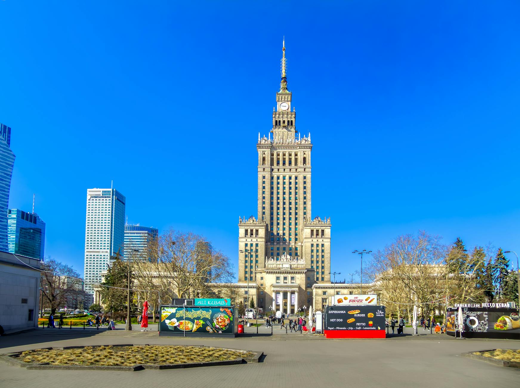 Ilustracja symbolizująca napięcia w Warszawie: połączenie sceny z życia miejskiego i symboli Unii Europejskiej.